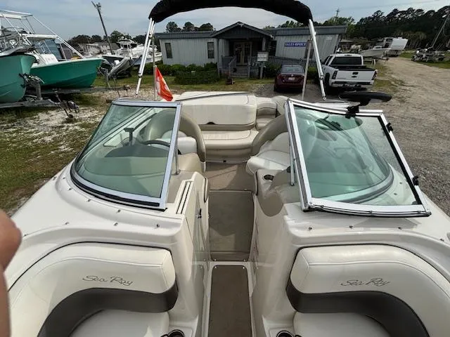 Slide: The Image of 2006 Sea Ray 200 Select boat interior with open seating and windshield, parked outdoors. - 27