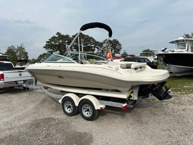 Slide: The Image of 2006 Sea Ray 200 Select boat on trailer, parked outdoors, with trees and other boats in background. - 9