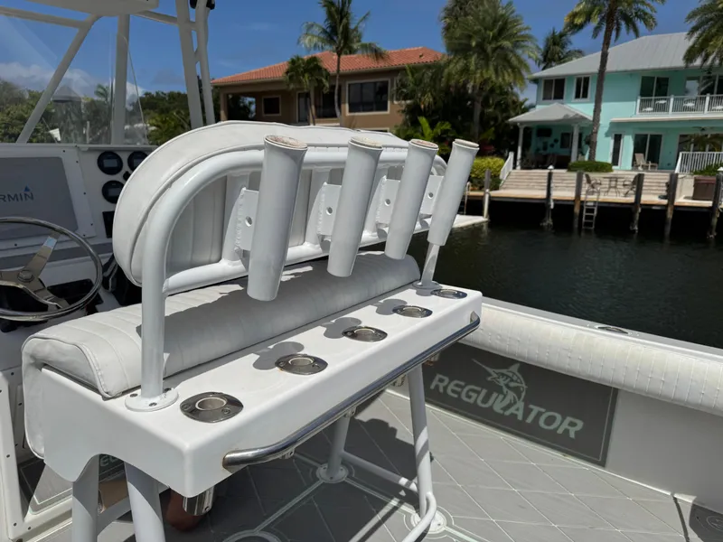 Slide: The Image of 2005 Regulator 23 Center Console boat with rod holders, docked near waterfront homes. - 15