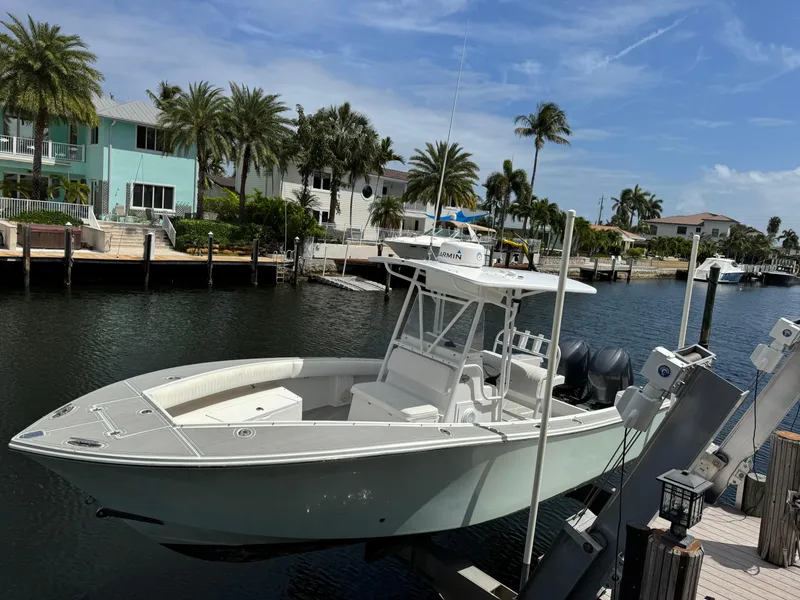 Slide: The Image of 2005 Regulator 23 Center Console boat docked by waterfront homes and palm trees. - 4