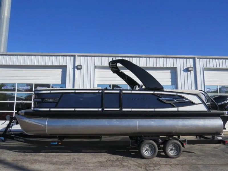 Slide: The Image of 2023 Godfrey AquaPatio 255 ULC pontoon boat on trailer, parked outside a building. - 3
