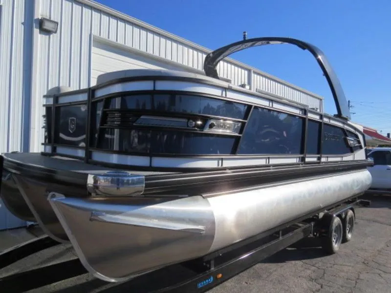 Slide: The Image of 2023 Godfrey AquaPatio 255 ULC pontoon boat on trailer, parked outside a building. - 4