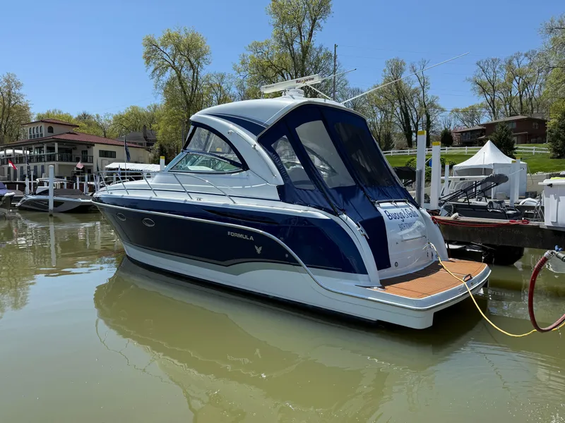 Slide: The Image of 2011 Formula 340PC boat docked on a sunny day, surrounded by trees and buildings. - 15