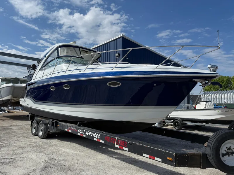 Slide: The Image of 2011 Formula 340PC boat on trailer, blue and white, parked outdoors under a clear sky. - 9