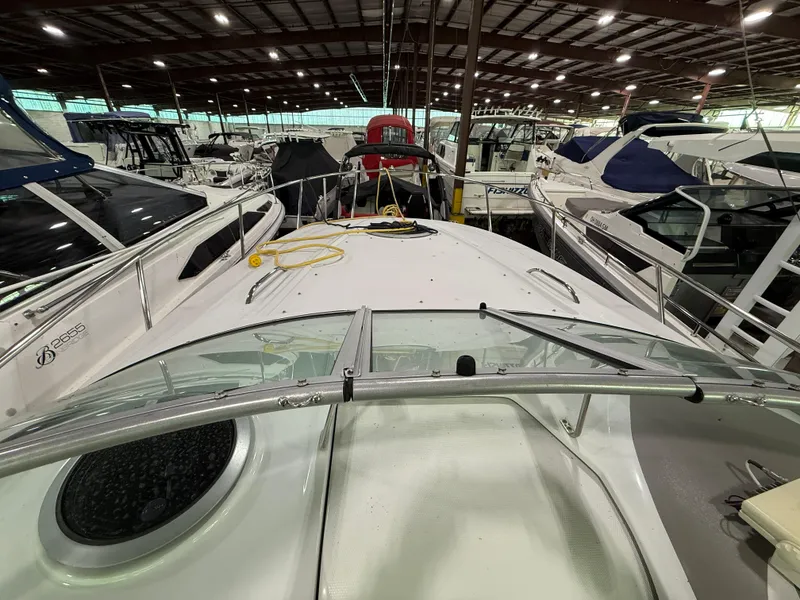 Slide: The Image of 2007 Crownline 250 CR boat in indoor marina, surrounded by other vessels. - 11
