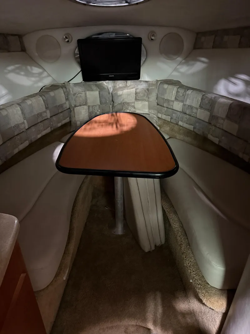 Slide: The Image of Interior of a 2007 Crownline 250 CR boat with cozy seating and a mounted TV. - 12