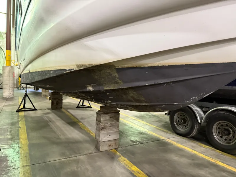 Slide: The Image of 2007 Crownline 250 CR boat on blocks in a garage, showing hull and trailer. - 17