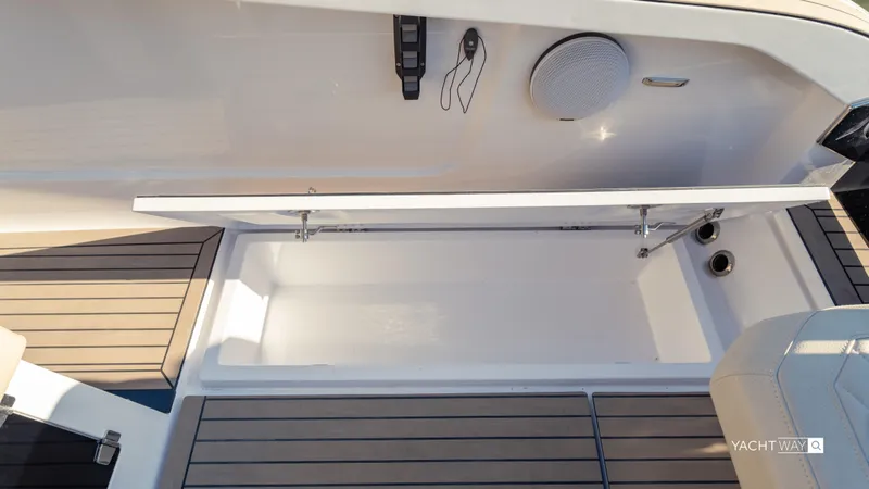 Slide: The Image of Open storage compartment on 2025 Rand Roamer boat with wooden deck accents. - 5