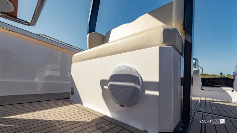 Slide: The Image of 2025 Rand Roamer boat interior with cushioned seating and speaker on deck. - 7