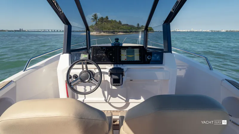 Slide: The Image of 2025 Rand Roamer boat cockpit with modern controls, steering wheel, and ocean view. - 8
