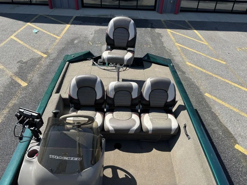 Slide: The Image of 2004 Tracker Pro Team 185 boat with seating and steering console in a parking lot. - 15