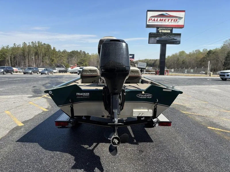Slide: The Image of 2004 Tracker Pro Team 185 boat with outboard motor in parking lot, dealership sign visible. - 4