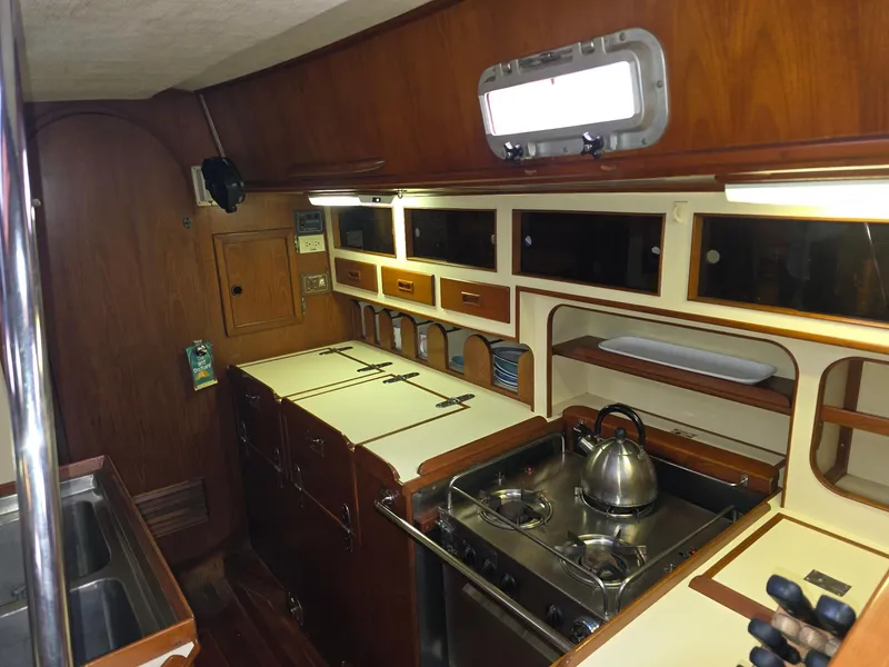 Slide: The Image of 1982 Stevens 40" yacht kitchen with wooden cabinets, stove, and sink. - 12