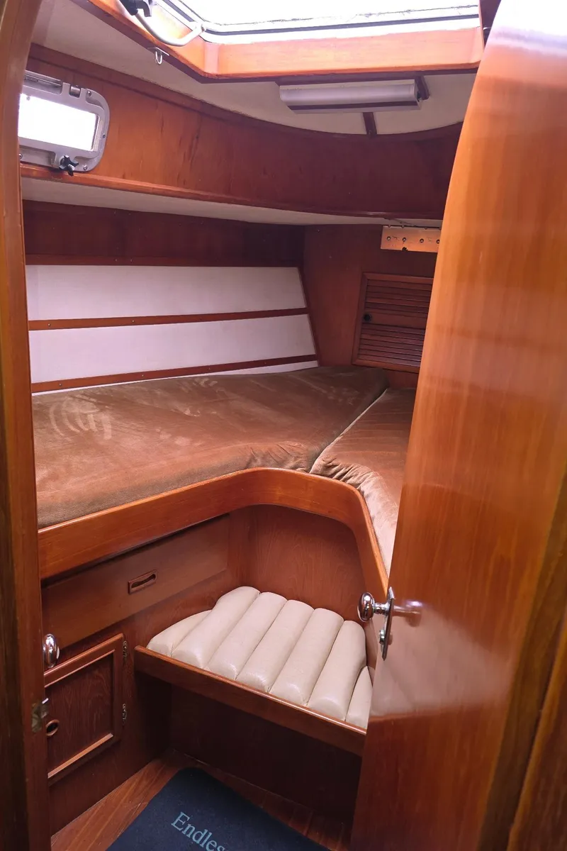 Slide: The Image of Cozy cabin interior of a 1982 Stevens 40" yacht with wooden furnishings and cushioned seating. - 21