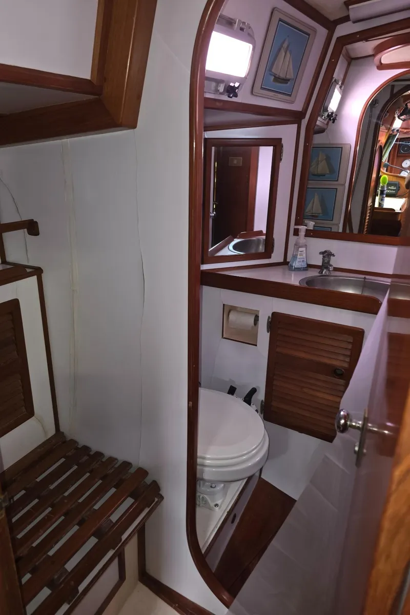 Slide: The Image of 1982 Stevens 40" yacht bathroom with wooden accents, mirror, and nautical decor. - 26