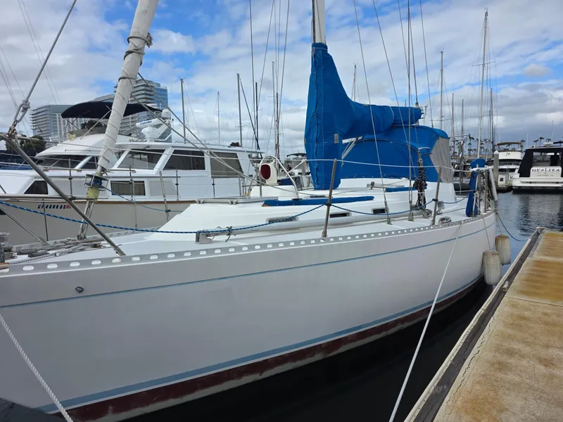 Slide: The Image of 1982 Stevens 40" sailboat docked at marina, featuring blue sail cover and white hull. - 3