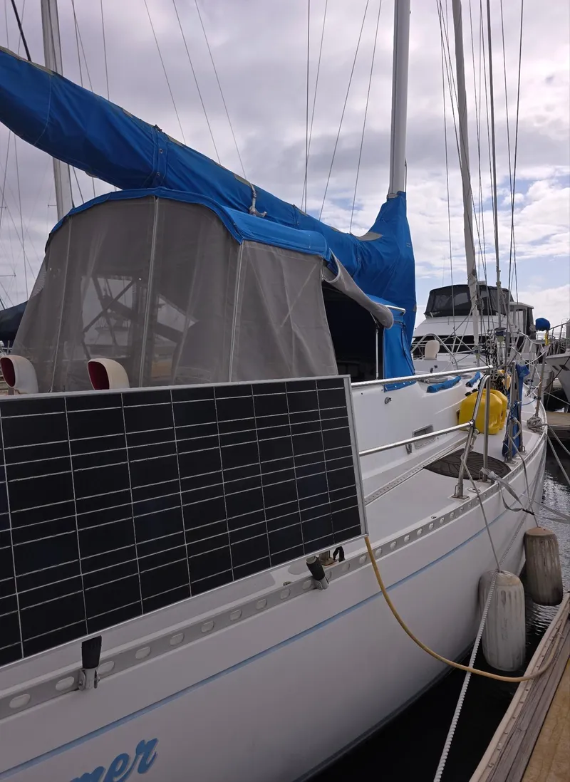 Slide: The Image of 1982 Stevens 40" sailboat with blue cover and solar panel, docked at marina. - 36