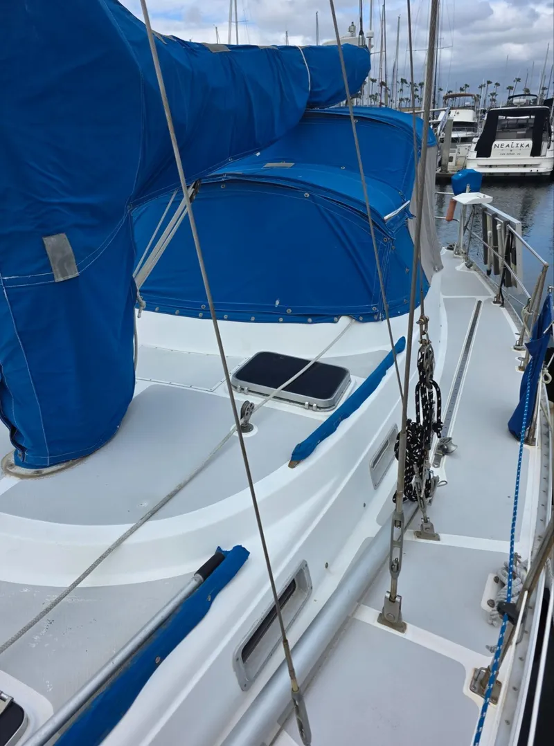 Slide: The Image of 1982 Stevens 40" sailboat with blue covers docked in a marina. - 37