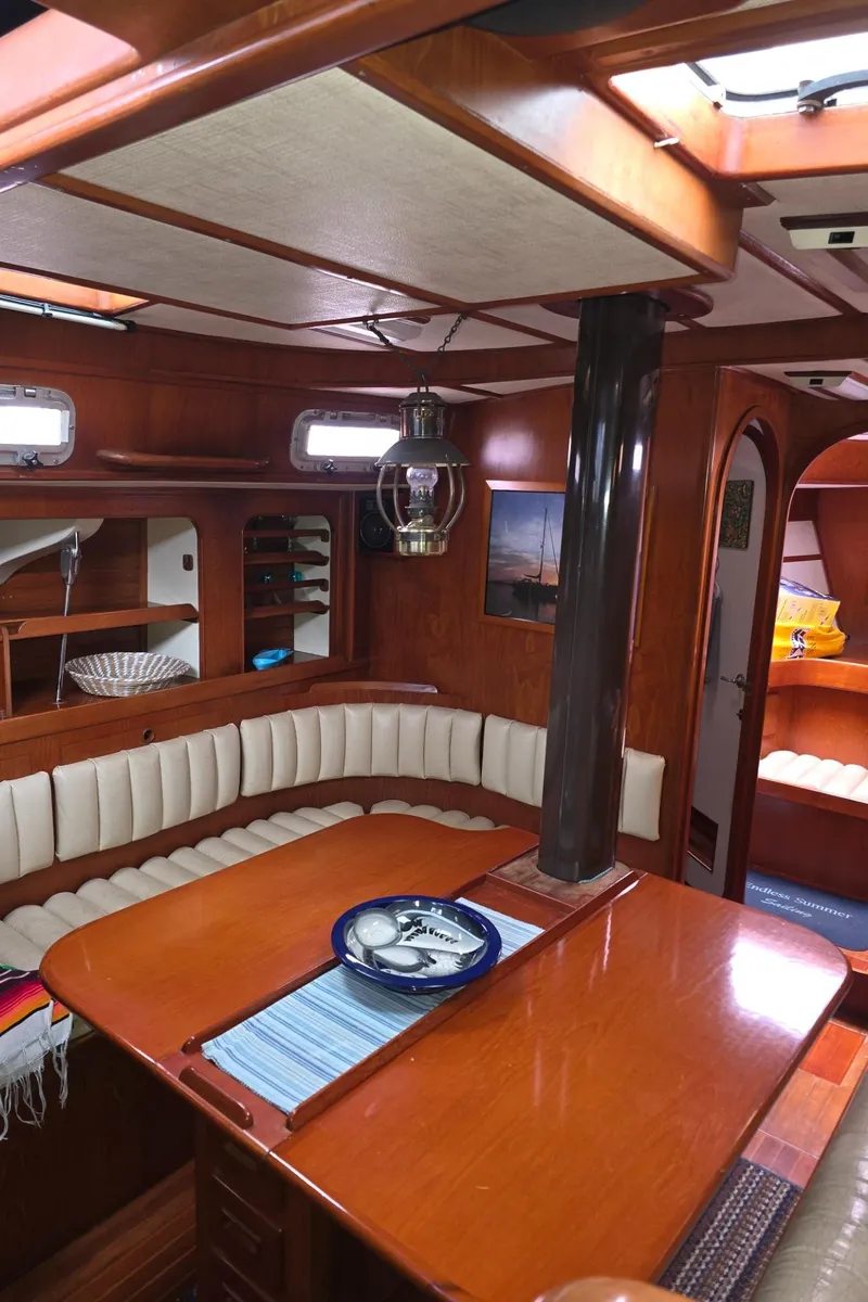 Slide: The Image of Interior of a 1982 Stevens 40" yacht with wooden dining area and cushioned seating. - 9