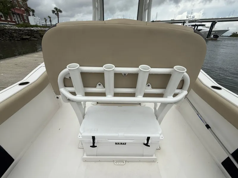 Slide: The Image of 2022 Tidewater 232 CC Adventure boat interior with rod holders and cooler. - 14