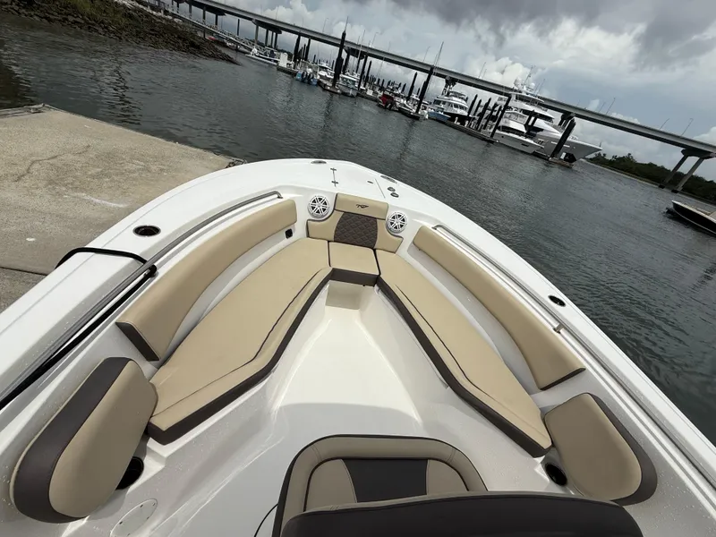 Slide: The Image of 2022 Tidewater 232 CC Adventure boat with spacious seating, docked near a bridge. - 19