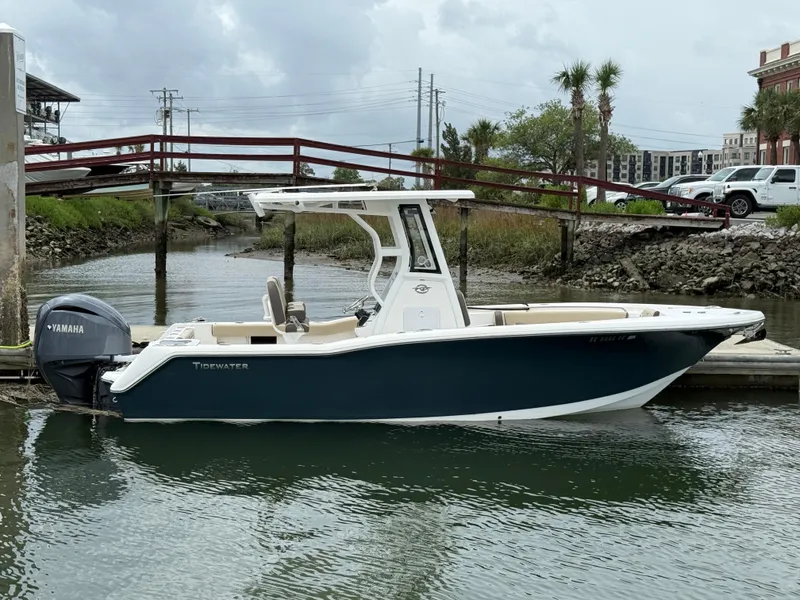 Slide: The Image of 2022 Tidewater 232 CC Adventure boat docked in a marina, featuring a sleek design and Yamaha engine. - 2