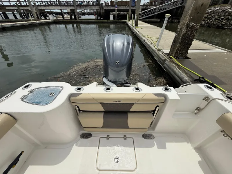 Slide: The Image of 2022 Tidewater 232 CC Adventure boat docked, featuring a sleek outboard motor. - 21