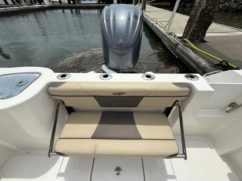 Slide: The Image of 2022 Tidewater 232 CC Adventure boat with cushioned seating and outboard motor at dock. - 22