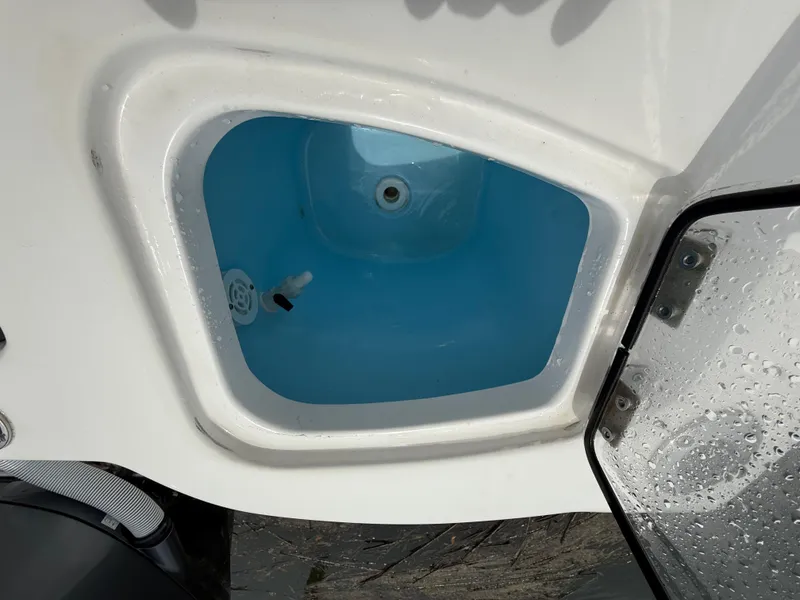 Slide: The Image of Livewell compartment on a 2022 Tidewater 232 CC Adventure boat, featuring a blue interior. - 26