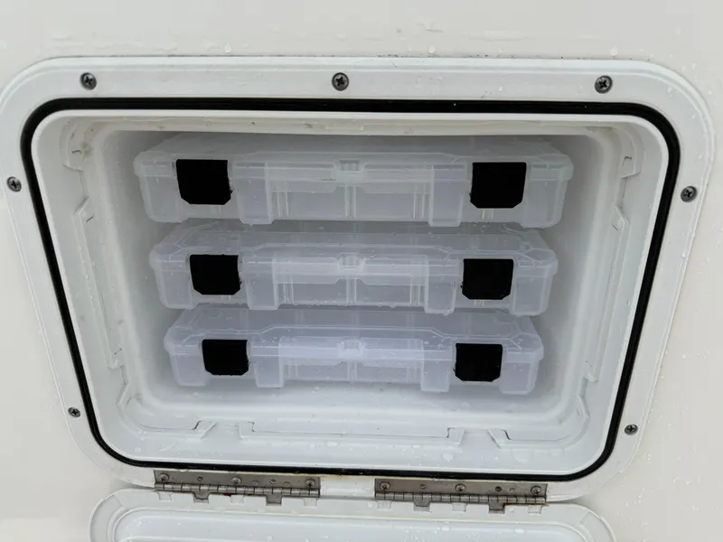 Slide: The Image of Storage compartment with tackle boxes on a 2022 Tidewater 232 CC Adventure boat. - 28