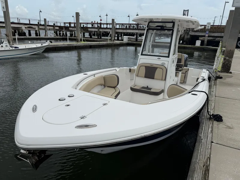 Slide: The Image of 2022 Tidewater 232 CC Adventure boat docked at marina, featuring sleek design and spacious seating. - 4