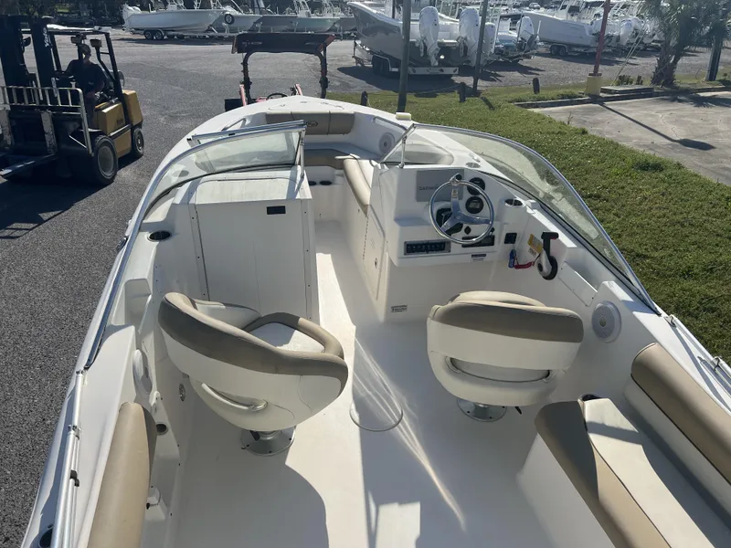 Slide: The Image of 2020 Key West 203DFS boat interior with seating and steering wheel, parked outdoors. - 3