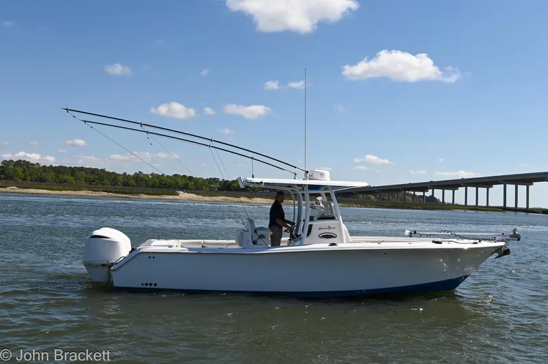 Slide: The Image of 2014 Sea Hunt Gamefish 30 boat on water, bridge in background, clear sky. - 0