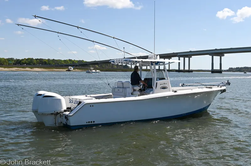 Slide: The Image of 2014 Sea Hunt Gamefish 30 boat on water near a bridge, with fishing rods visible. - 1