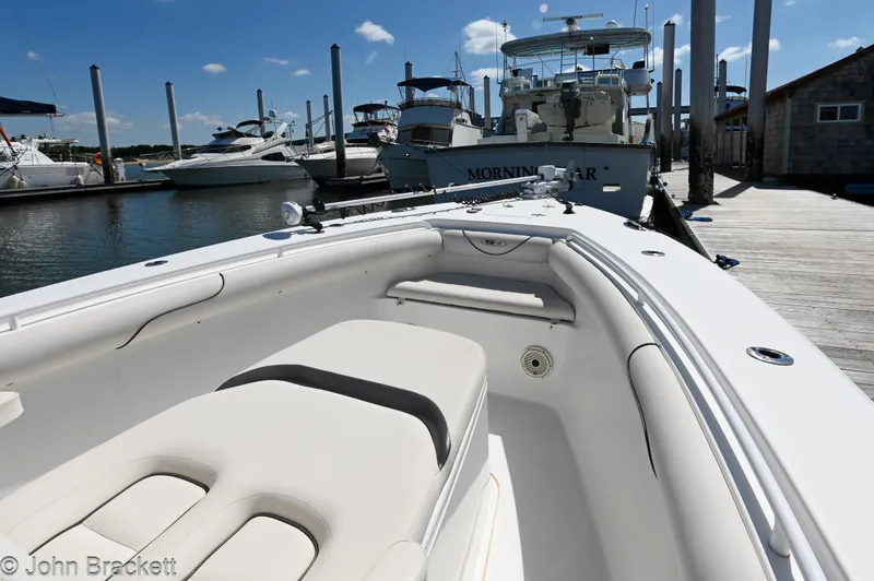 Slide: The Image of 2014 Sea Hunt Gamefish 30 boat docked at marina, showcasing spacious seating and sleek design. - 12