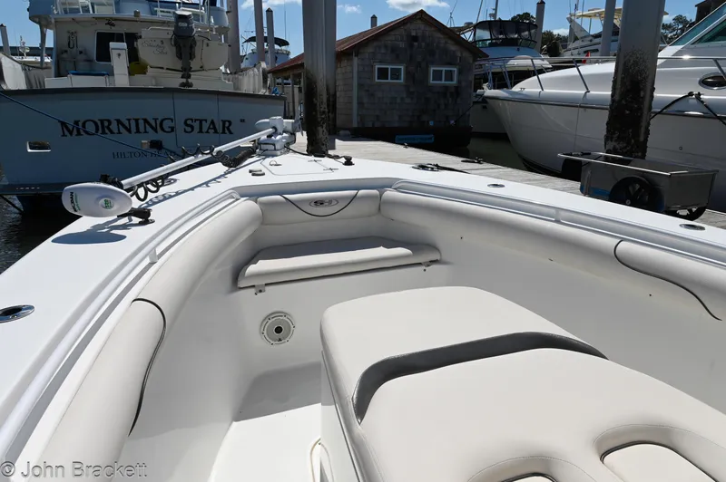 Slide: The Image of 2014 Sea Hunt Gamefish 30 boat interior at marina, featuring seating and equipment. - 14