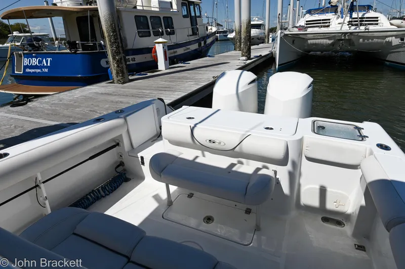 Slide: The Image of 2014 Sea Hunt Gamefish 30 at marina, featuring spacious deck and twin engines. - 16