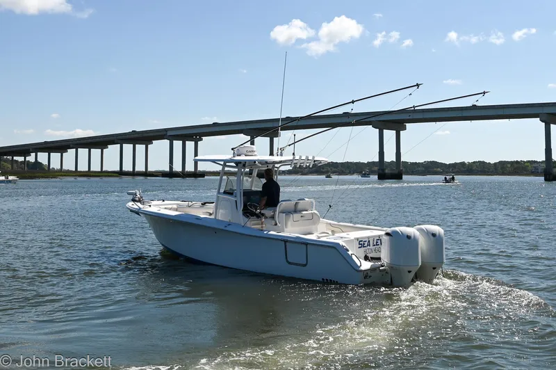 Slide: The Image of 2014 Sea Hunt Gamefish 30 boat cruising near a bridge on a sunny day. - 8