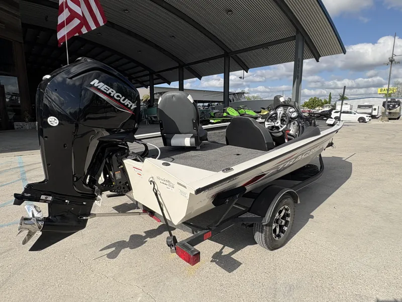 Slide: The Image of 2020 Tracker Pro Team 175 boat with Mercury engine, parked outdoors under a canopy. - 7