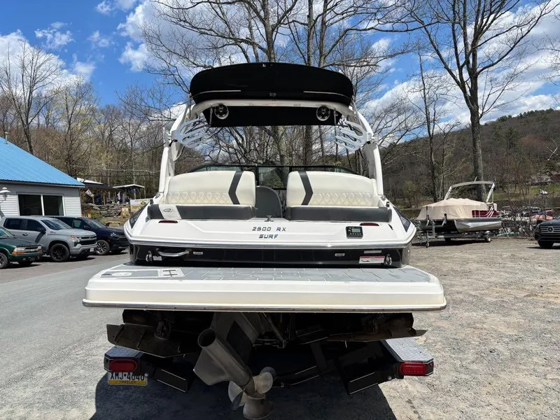 Slide: The Image of 2019 Regal 25 RX Surf boat, rear view, parked outdoors on a sunny day. - 7