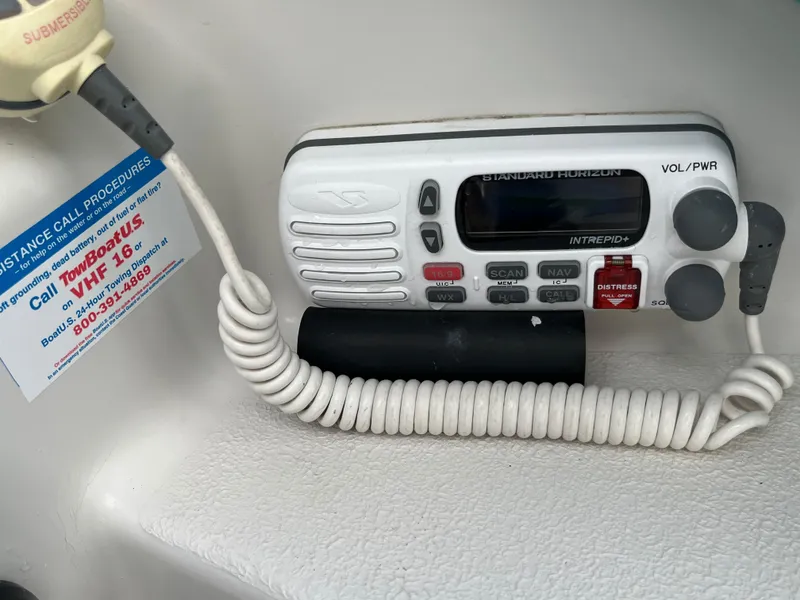 Slide: The Image of VHF marine radio with distress call button and coiled cord on a PDQ 32 boat. - 13