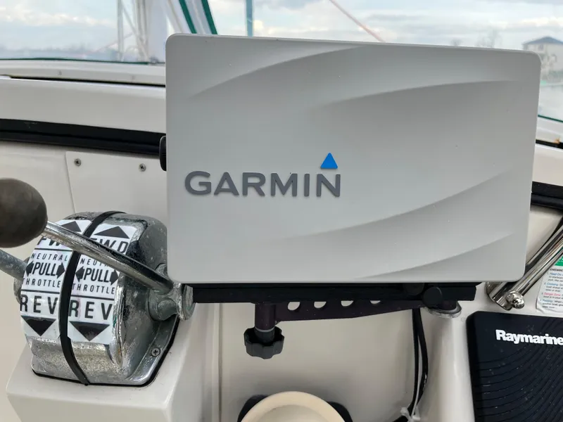 Slide: The Image of Boat dashboard with Garmin GPS, throttle controls, and Raymarine equipment, PDQ 32, 2003 model. - 14