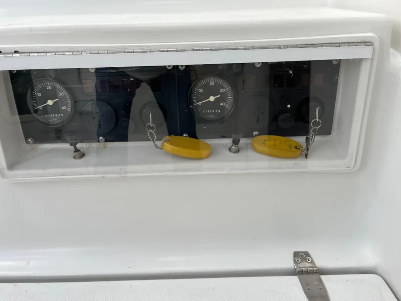 Slide: The Image of Control panel of a 2003 PDQ 32 boat with gauges and yellow keychains. - 15