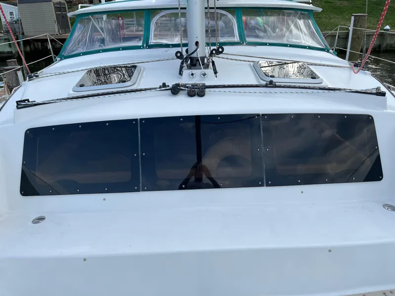 Slide: The Image of 2003 PDQ 32 sailboat with tinted windows, docked at a marina. - 20