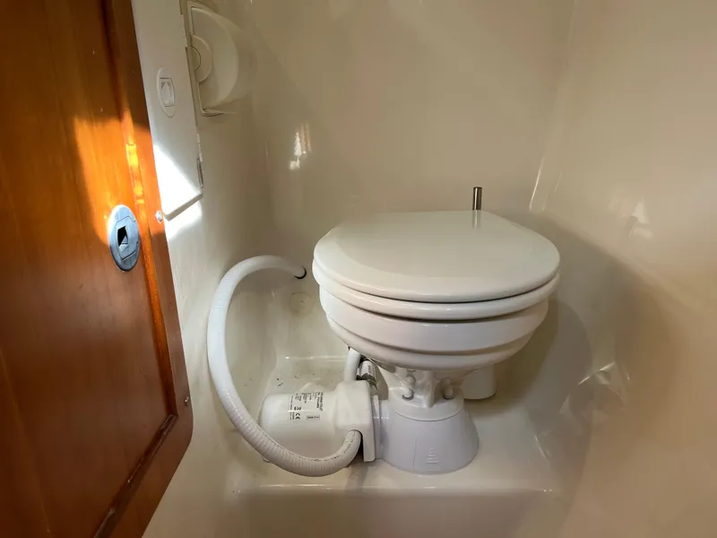 Slide: The Image of Compact marine toilet in a PDQ 32 boat, 2003 model, with wooden door and white fixtures. - 29