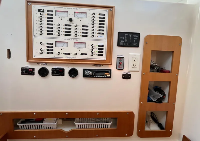 Slide: The Image of Electrical control panel on a 2003 PDQ 32 boat, featuring various switches and gauges. - 31