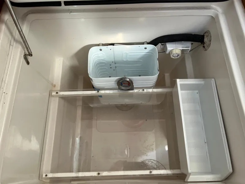 Slide: The Image of Open compartment of a 2003 PDQ 32 boat, featuring storage and utility sections. - 38