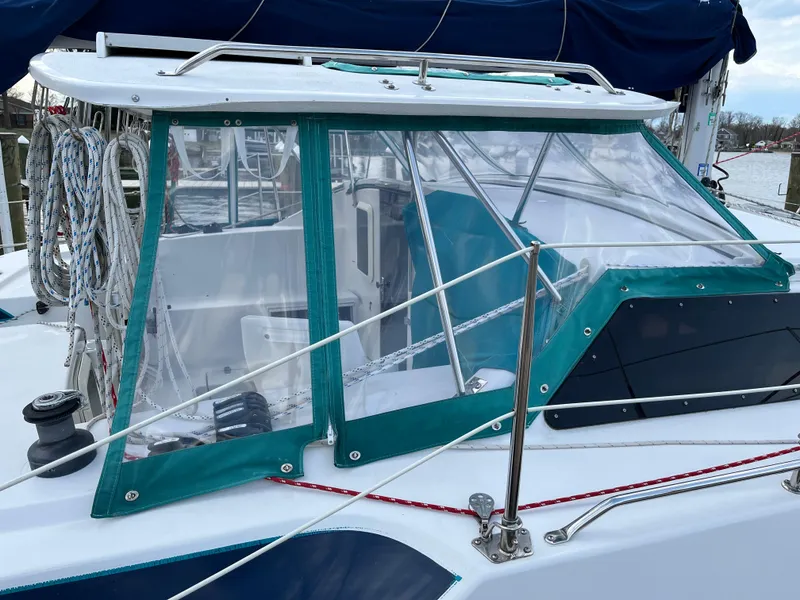 Slide: The Image of 2003 PDQ 32 sailboat cockpit with clear enclosure and ropes, docked by the water. - 4