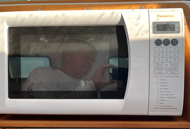 Slide: The Image of White Panasonic microwave with digital display and control panel, reflecting a person. - 45