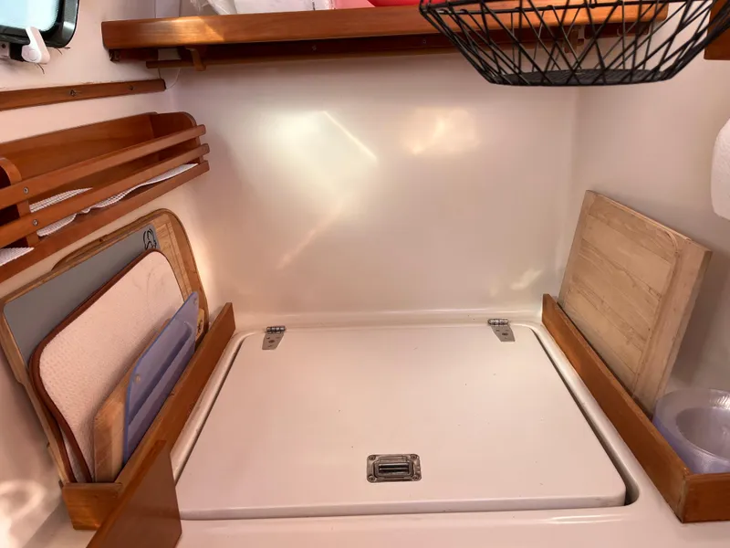 Slide: The Image of Compact kitchen area in a 2003 PDQ 32 boat with cutting boards and storage. - 46